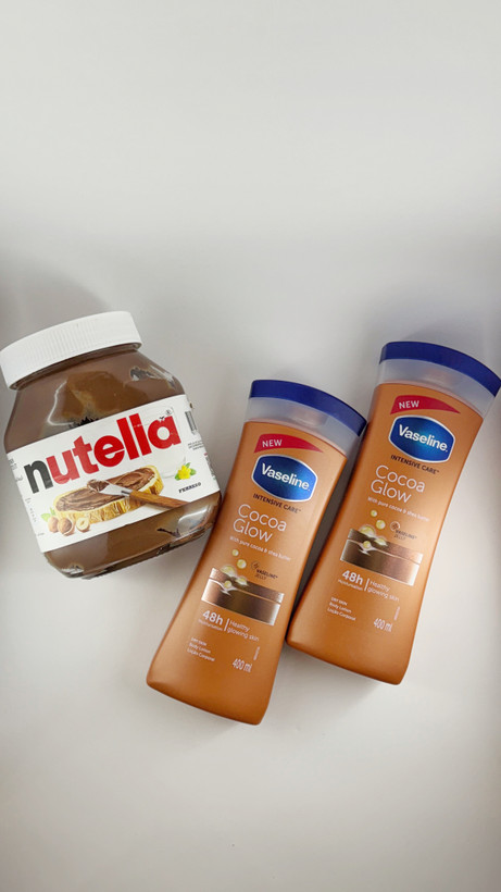 تصویر لوسیون بدن وازلین و شکلات نوتلا روی میز