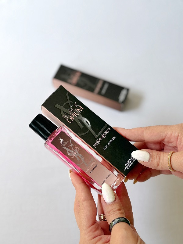 تصویر ادکلن زنانه الحمبرا مدل بلک اوپیوم در دست | عطر-با-ماندگاری-بالا